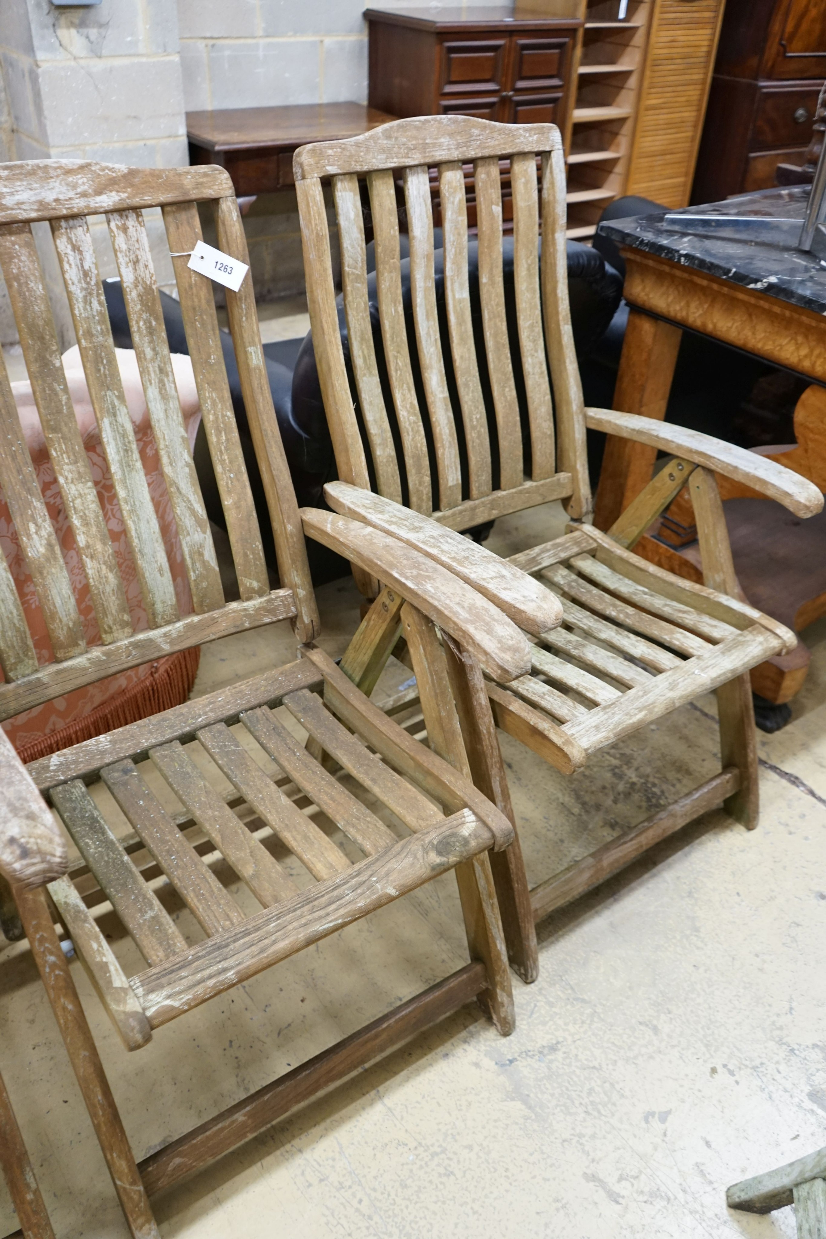 A set of four weathered teak folding garden armchairs, width 63cm, depth 56cm, height 114cm